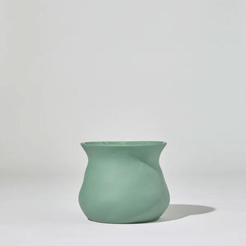 A short round vase with a curved top in green ceramic against a grey background.