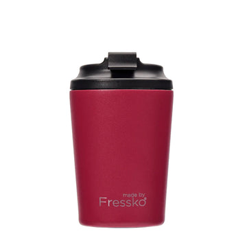A reusable coffee cup in a dark red with a black lid and the text 'made by Fressko' on the bottom.