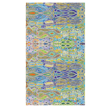 A sarong is laid out flat showing the artwork by Judy Watson featuring blue, green and orange shapes.
