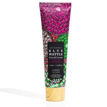 A small tube of hand cream featuring artwork by Coral Hayes with a black product label and wood look lid.