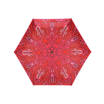 Top down view of an open umbrella with a red  design by Jeannie Petyarre.