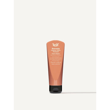 A small tube of hand cream with an orange brown exterior and black lid. The tube has product information on it.