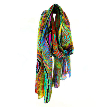 A multicoloured cotton scarf is laid like its draped around a neck. The scarf is printed with artwork by Liddy Napanangka Walker.
