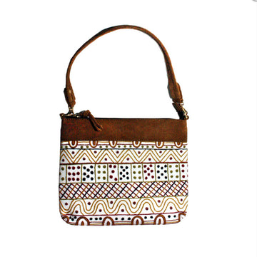 An embroidered handbag with a short brown strap and a pattern by Josette Papajua on the front in brown and white.