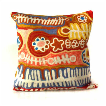 A cushion cover made from chain stitched wool printed with artwork by Murdie Morris in browns, yellows and blues.