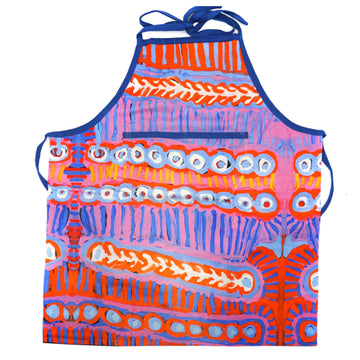 An apron is laid out flat featuring artwork in red and blue by Murdie Nampijinpa Morris.