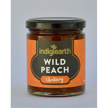 A clear jar with a black lid and wide product label. The label says 'Indigiearth Wild Peach Chutney' on a black and orange background.