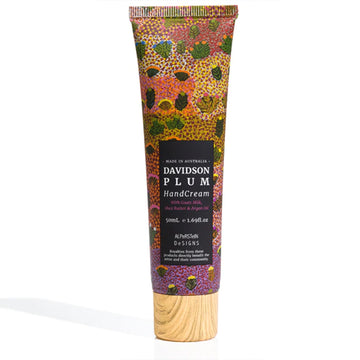 A tube of hand cream featuring artwork by Daisy Kemarre Moss with a black product label and wood look lid.