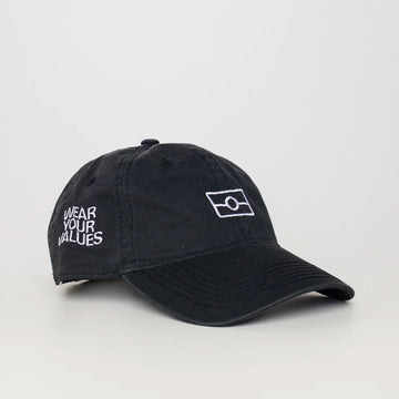 Front and side view of a black cap with the Aboriginal flag line drawing embroidered on the front and the text 'Wear Your Values' on the side.
