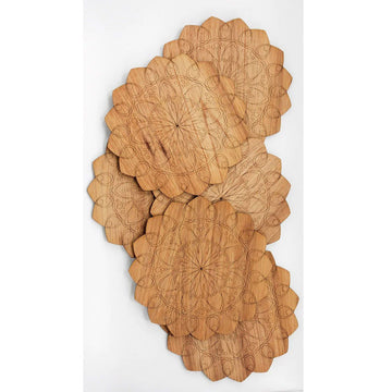 Six wooden place mats stacked over each other each printed with a mandala design.