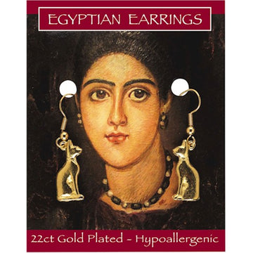 A pair of gold drop earrings in the shape of a cat on a backing card. The card has an illustration of a woman's face and the title 'Egyptian Earrings'.