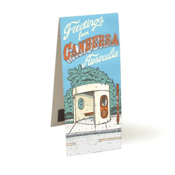 A magnetic bookmark standing open and printed with an illustration of a bus shelter by Trevor Dickinson. It has the heading 'Greetings from Canberra Australia'.