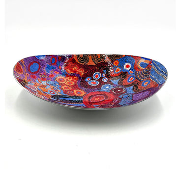 A long oval shaped stainless steel bowl printed with artwork by Andrea Mimpitja Adamson inside.