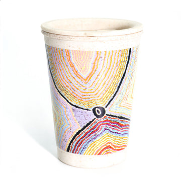 A bamboo travel mug printed with artwork by Liddy Napanangka Walker in yellow, black and red.
