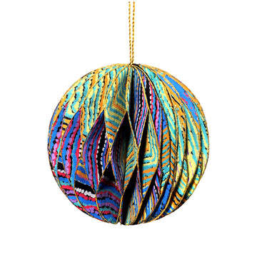 A paper christmas bauble with a honeycomb shape connecting the layers of paper. The bauble is printed with artwork by Liddy Walker in purple, green and blue.