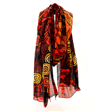 A cotton scarf printed with artwork by Damien and Yilpi Marks in orange and brown.