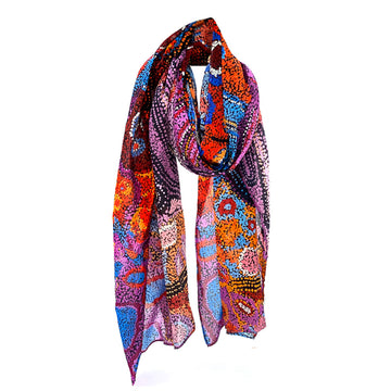 A cotton scarf printed with artwork by Andrea Mimpitja Adamson in different colours.