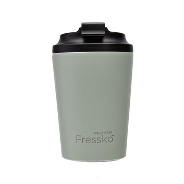 A reusable coffee cup in a sage green with a black lid. The text 'made by Fressko' is written on the front.