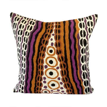 A chain stitched cushion cover featuring artwork by Angilyiya Mitchell in mustard, purple and cream. There are vertical lines and circles.