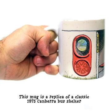 A mug is pictured in the centre which has been printed to look like a Canberra bus shelter. The text 'A Bus Shelter Mug 1975 Canberra Classic' is written above the mug and 'The original bus stop mug' is written underneath the mug.