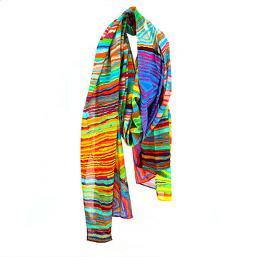 A cotton scarf printed with artwork by Judy Watson is wrapped up like its being worn around a neck.