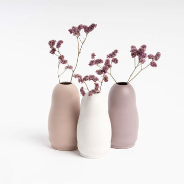 A small ceramic vase in white with a rounded shape.