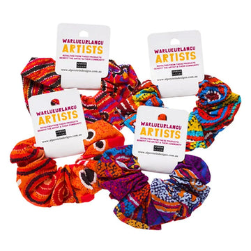 Four scrunchies pictured each with a white product tag on them with the text 'Warlukurlangu Artists'.