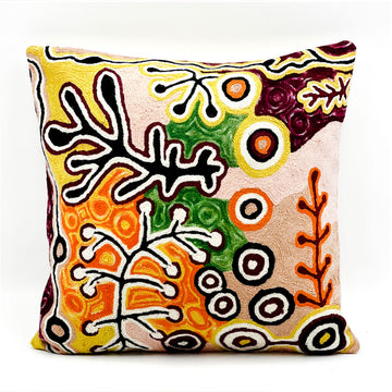 A chain stitched cushion featuring artwork by Paddy Stewart in shades of brown and orange with black and white.