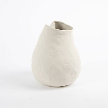 A white handcrafted vase in an irregular round shape.
