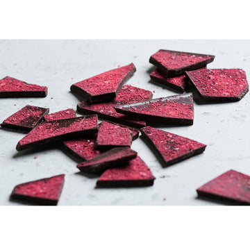 Front of a block of chocolate inside a colourful box with Aboriginal artwork and the title 'Davidson Plum & Murray River Salt 63% Dark Chocolate'.