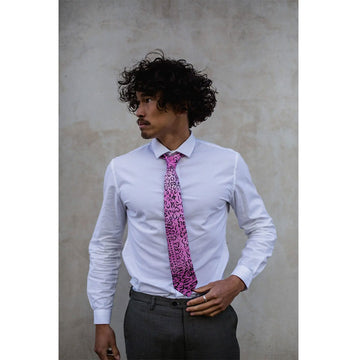 A pink tie with black lines, circles and dots featuring artwork by Helen Dale Samson.