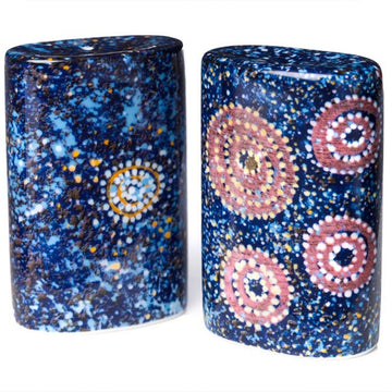 A pair of salt and pepper shakers in blue with artwork by Alma Granites. The artwork is made up of pink, yellow and white circles painted with dots.