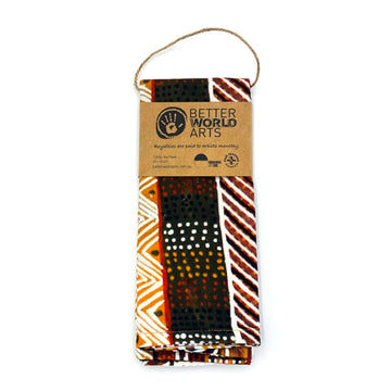 A tea towel laid out featuring artwork by Josette Papajua in the colours of brown, orange and white.
