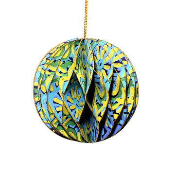 A paper christmas bauble with a honeycomb shape joining the layers and printed with artwork by Cedric Varcoe.