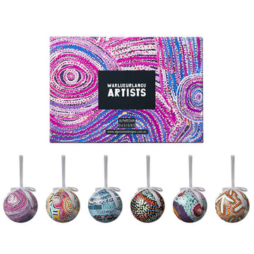 Six baubles each printed with artwork by a different artist. The box lid is also pictured above the baubles with artwork in purple and pink.