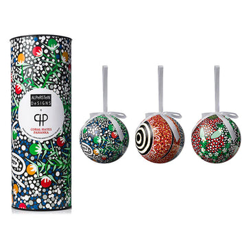 Three baubles pictured next to their packaging tube. They are all printed with artwork by Coral Hayes.
