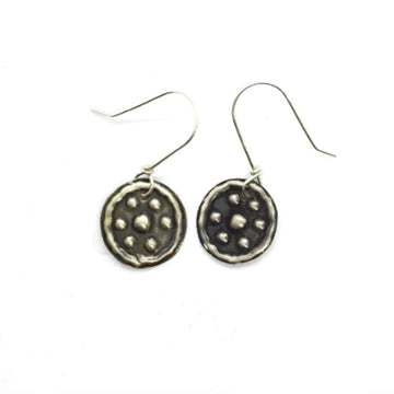 A pair of drop earrings with a flat circle embossed with seven dots and a border.