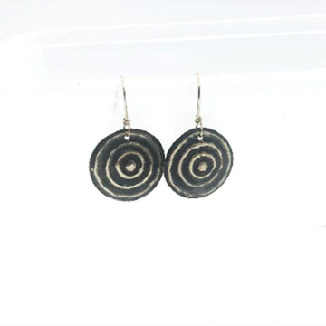 A pair of drop earrings in sterling silver in the shape of a circle with embossed circles inside.