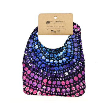 A cotton baby bib printed with artwork by Olivia Wilson and a brown product tag at the top.