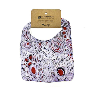 A cotton baby bib printed with artwork by Cedric Varcoe and a brown product tag at the top.