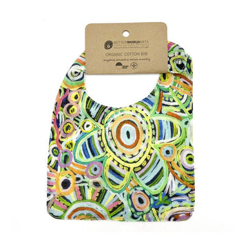 A cotton baby bib printed with artwork by Cedric Varcoe and a brown product tag at the top.