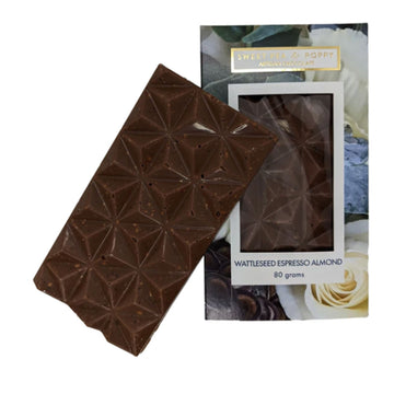 A block of chocolate is leaning against its packaging box. The chocolate has a 3D&nbsp;triangle design and the box is printed with flowers with a window in the middle showing the chocolate inside.