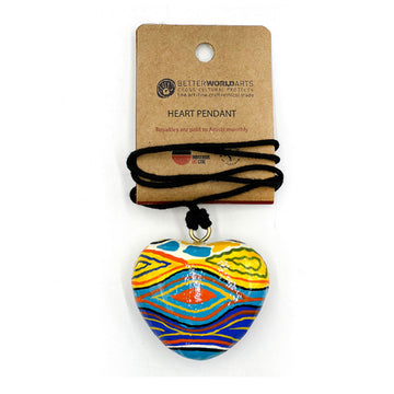 A heart shaped pendant printed with artwork by Judy Watson on a black cord attached to a brown product card.