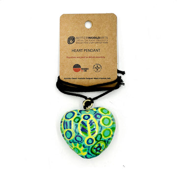 A heart shaped pendant printed with artwork by Cedric Varcoe on a black cord attached to a brown product card.