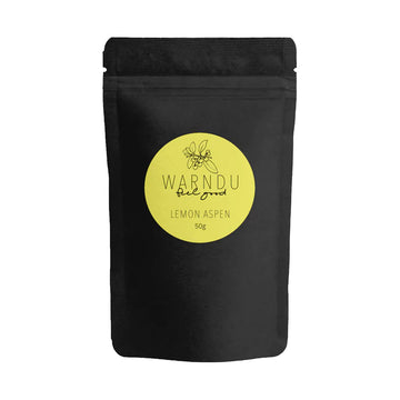 A black packet with a round yellow sticker on the front with the text 'Warndu Feel Good Lemon Aspen'.