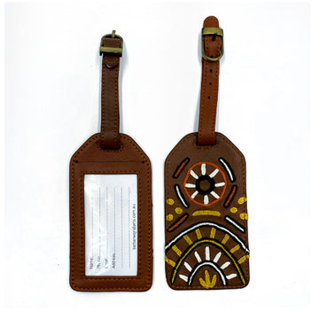 Front and back view of a luggage tag in brown with a clear sleeve on the back and embroidered with artwork by Nina Puruntatameri on the front.