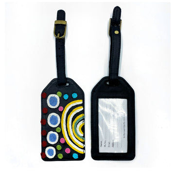 Front and back view of a luggage tag in black with a clear sleeve on the back and embroidered with artwork by Yaritji Heffernan on the front.