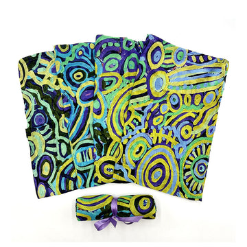 A baby swaddle is fanned out and printed with artwork by Cedric Varcoe. There is another one rolled up in front.