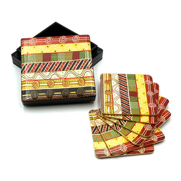 A set of coasters are laying fanned out next to a matching box. They are printed with artwork by Josette Papajua.