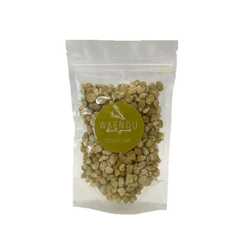 A clear bag filled with desert lime chips and a green round label with the text 'Warndu Feel Good Desert Lime'.
